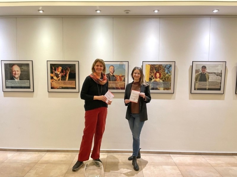 Foto der Ausstellung: zwei Menschen stehen vor den Bildern