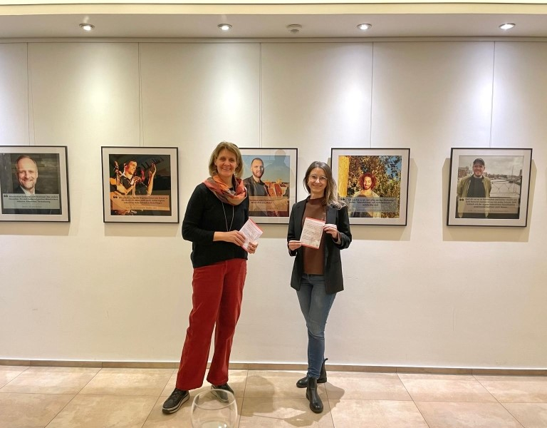 Foto der Ausstellung: zwei Menschen stehen vor den Bildern